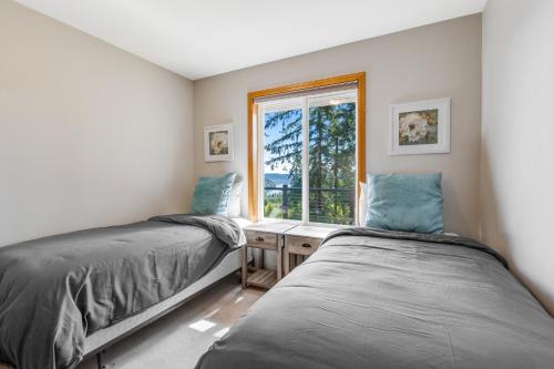two beds in a room with a window at Hubbard Hill Haven in La Conner
