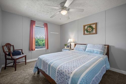 una camera con letto, ventilatore a soffitto e sedia di Eatonton Home with Dock and Lake Sinclair Views! a Eatonton