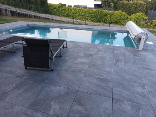 - une piscine avec une table et un banc dans l'établissement chambre gite au pied du Vieil Armand, à Wattwiller