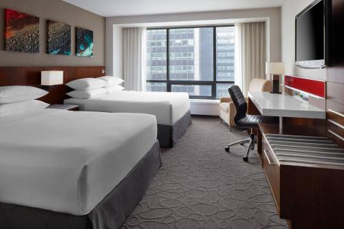 a hotel room with two beds and a desk at Delta Hotels by Marriott Ottawa City Centre in Ottawa