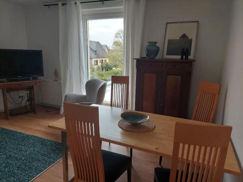 a dining room with a table and chairs and a television at Ferienwohnung Lojane in Kranenburg