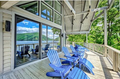 a porch with blue chairs and a view of the water at Our Point of View in Huddleston