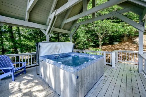 a hot tub on a deck with a blue chair at Our Point of View in Huddleston