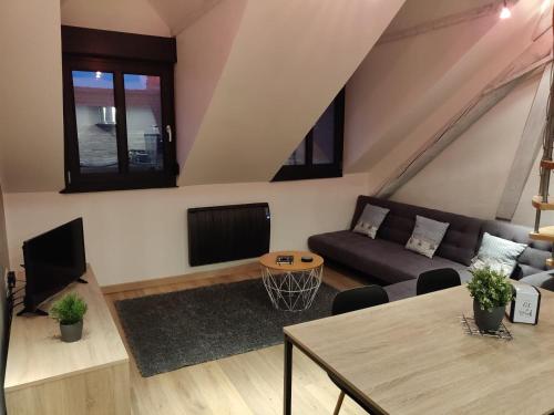 a living room with a couch and a table at Le business, duplex moderne special PRO de passage in Sarreguemines