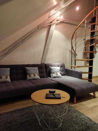 a living room with a couch and a table at Le business, duplex moderne special PRO de passage in Sarreguemines