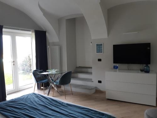 a bedroom with a television and a table and chairs at Sweet Home Canavese in Castellamonte