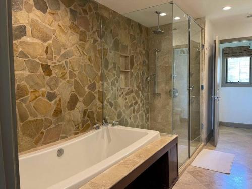La salle de bains est pourvue d'une baignoire et d'une douche en verre. dans l'établissement Lakeview Bungalow-Access to Lake, Pool, Gym, &Park, à Lago Vista