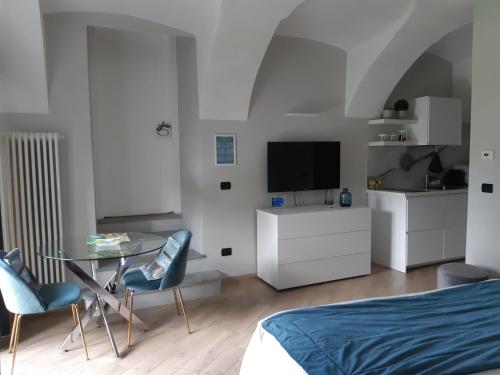 a bedroom with a bed and a table and a tv at Sweet Home Canavese in Castellamonte