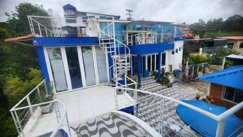 Cette maison bleue et blanche dispose d'un balcon. dans l'établissement Hotel spa la buena vida, à Fusagasuga