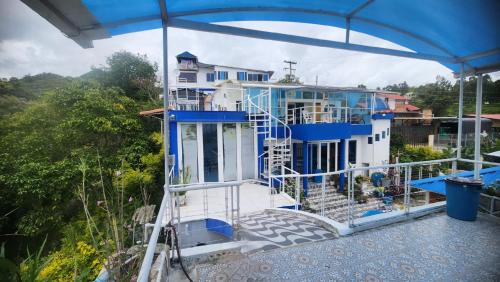 a blue and white house with a balcony at Hotel spa la buena vida in Fusagasuga