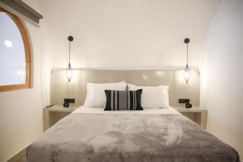 1 dormitorio con 1 cama grande y 2 lámparas en Luxury Canava en Emporio Santorini