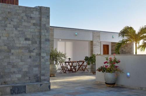 a house with a courtyard with a table and palm trees at Aiolos Hotel & Discoveries in Prea