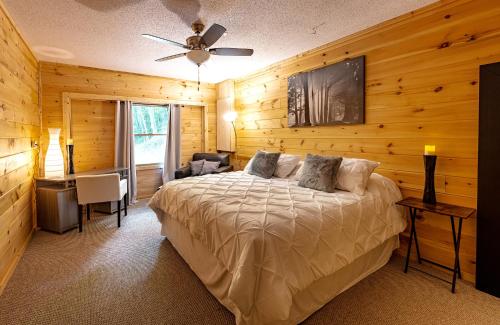 a bedroom with a bed in a room with wooden walls at Lakeside Mountain Oasis - 3 Bedroom Cabin with Outdoor Hot Tub in Topton