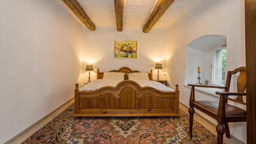 ein Schlafzimmer mit einem Holzbett in einem Zimmer in der Unterkunft Kretscham Tauchritz Gästehäuser "Alte Brennerei" am Berzdorfer See bei Görlitz in Görlitz