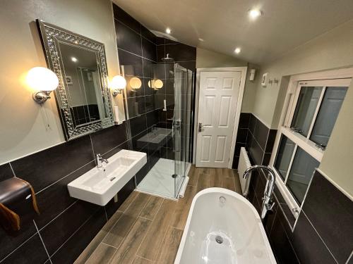 a bathroom with a tub and a sink and a shower at Birches Brow Boutique Guest Rooms in Aughton