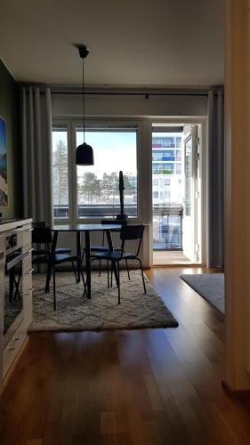 uma sala de jantar com mesa e cadeiras e uma grande janela em Hyvän unen huoneisto em Rovaniemi
