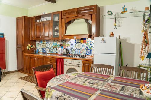 Casarella Chiara في نابولي: مطبخ مع طاولة وثلاجة بيضاء