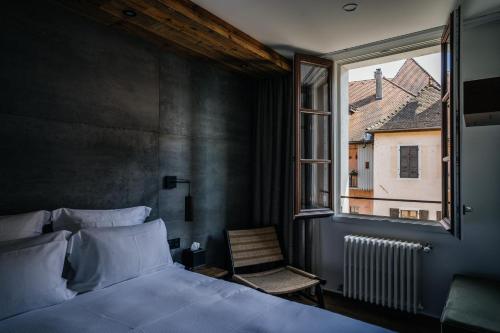 アヌシーにあるAuberge du Lyonnaisのベッドルーム1室(ベッド1台、窓、椅子付)