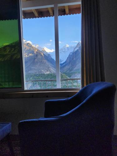 a chair in front of a window with a view at Hunza Lounge in Hunza
