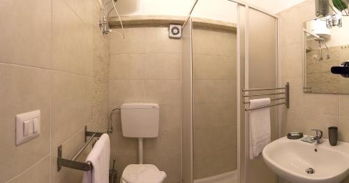 ein Bad mit einem Waschbecken, einem WC und einer Dusche in der Unterkunft Eidos in Taormina