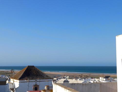 a view of the ocean from a building at Casa Malakita with private seaview roof terrace in Conil de la Frontera