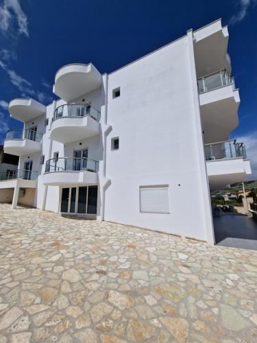 a white building with balconies on the side of it at Vila Klari in Ksamil