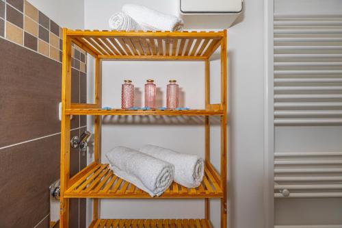 La salle de bains est pourvue d'une étagère en bois et de serviettes. dans l'établissement Villa Rocca, à Crikvenica
