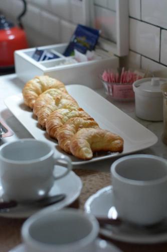 Una bandeja con croissants y tazas en un mostrador. en Rancho Contento Polo House, en Cañuelas