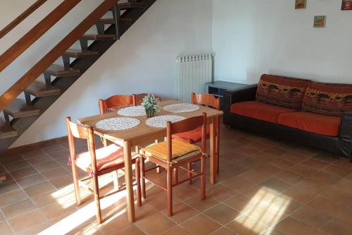 a table and chairs in a living room with a couch at la casetta in Montefiascone