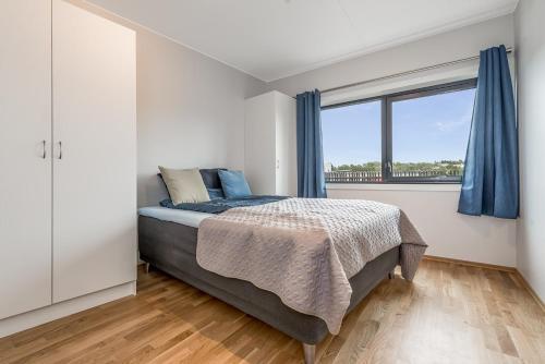 ein Schlafzimmer mit einem Bett und einem großen Fenster in der Unterkunft Apartments in Kjeller Lillestrøm - New, Modern and Central in Lillestrøm