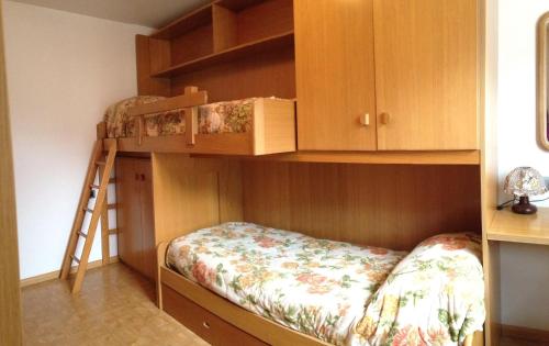 a bedroom with two bunk beds and a ladder at Ciasa Bocter in Moena