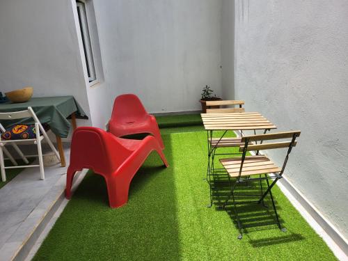 Iknews Appart Dakar في Kammba: غرفة بها طاولة وكراسي وعشب أخضر