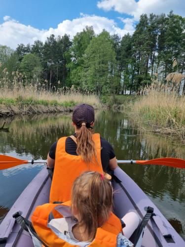 a woman and a child in a kayak on a river at Wiejska Chata in Barczewo