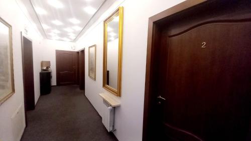 a hallway with a wooden door and a hallway with a mirror at Hotel i Restauracja 13 Smaków in Częstochowa
