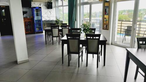a dining room with a table and chairs and windows at Hotel i Restauracja 13 Smaków in Częstochowa
