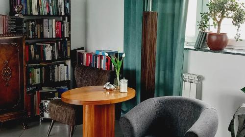 Habitación con mesa, sillas y estantería con libros. en Hotel i Restauracja 13 Smaków en Częstochowa