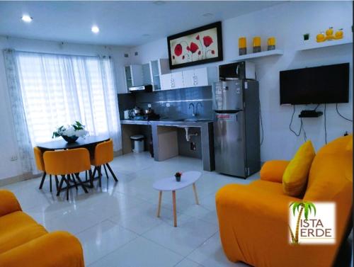 sala de estar con sofá amarillo y cocina en Apartamento Vacacional Vista Verde, en Tarapoto