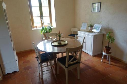 jadalnia ze stołem i krzesłami oraz oknem w obiekcie les épis de la joie w mieście Ligueil