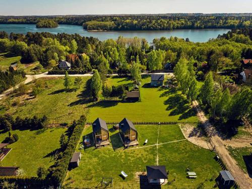 an aerial view of a house on a field with a lake at Sielski Chill Mazury in Olsztynek