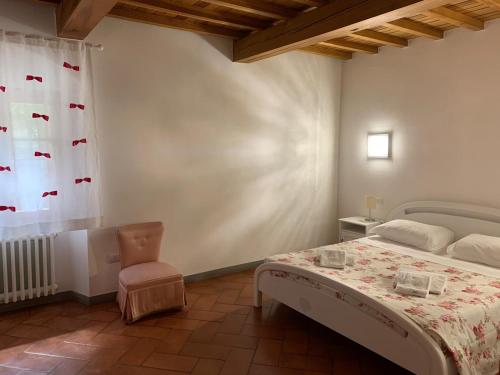 1 dormitorio con 1 cama, 1 silla y 1 ventana en B&B villa bianca, en SantʼAgata