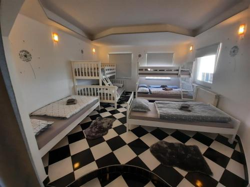 sypialnia z 2 łóżkami i podłogą wyłożoną szachownicą w obiekcie SUN RIVER KOLPA Ap Big w mieście Vinica