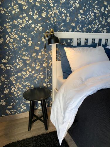 - une chambre avec du papier peint floral bleu, un lit et un tabouret dans l'établissement Chambre complètement indépendante !, à Limoges