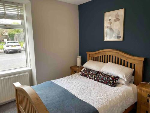 a bedroom with a bed with pillows and a window at James St Park 2 bed Gr Flr, sleeps 4 in Helensburgh