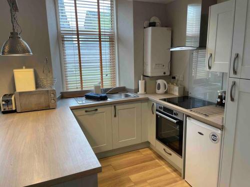 a kitchen with a sink and a stove top oven at James St Park 2 bed Gr Flr, sleeps 4 in Helensburgh
