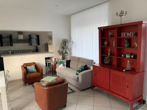 - un salon avec un canapé et une armoire rouge dans l'établissement Maison avec vue sur le Château, à Orléans