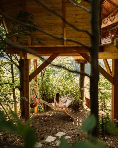 a woman sitting on a hammock in a tree house at Wild House Donovaly in Donovaly