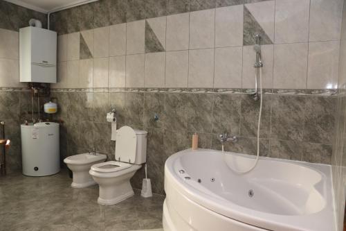 a bathroom with a tub and a toilet and a sink at Apartman NAOMI in Zagreb