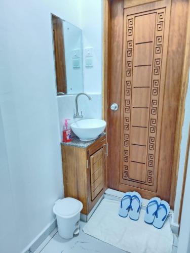 een badkamer met een wastafel, een toilet en slippers bij Airbn b Mombasa Bamburi in Mombasa