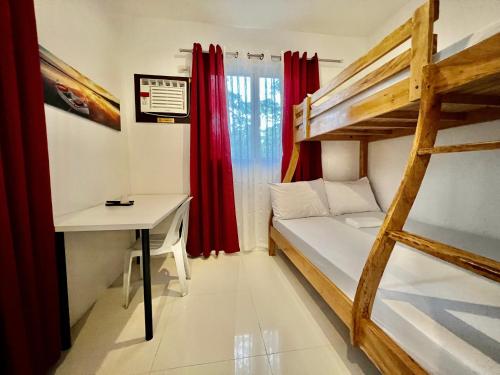 DipaculaoにあるBatis ni Juan Leisurelandのベッド、デスク、二段ベッドが備わる客室です。