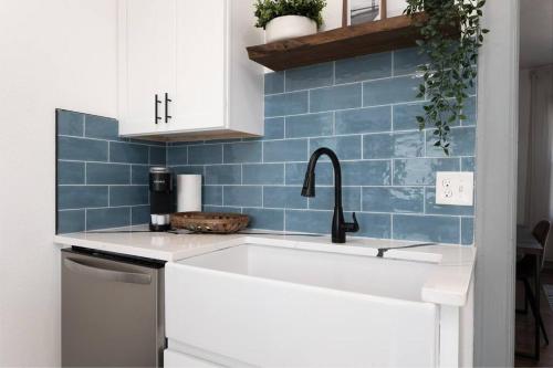 a kitchen with a sink and a blue tile wall at Walking distance to JAGS Stadium & Downtown in Jacksonville